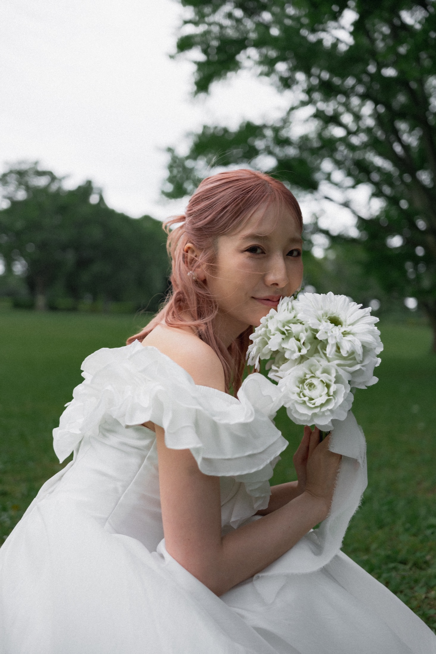 昭和の森の緑を背景に白いブーケを持つ花嫁